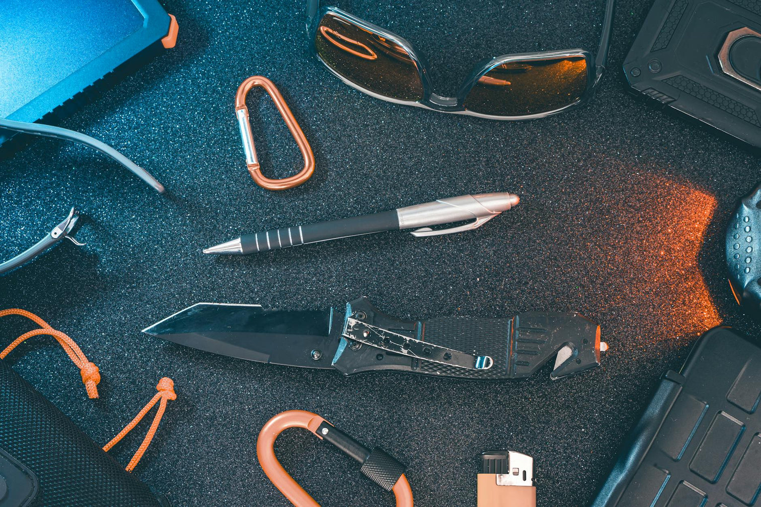 EDC gear flat lay with folding knife on dark foam, banner for OTF knife maintenance